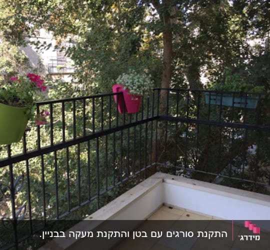 עציצים תלויים על מעקה מרפסת עם עצים ברקע